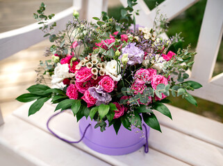 Large beautiful gift bouquet with red and white roses and greenery in a decorative basket.