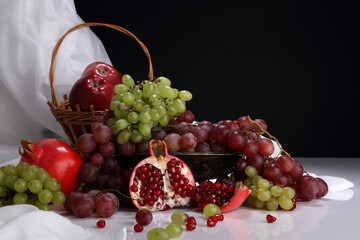 Still life on the theme of the harvest with pomegranate, grapes and apples