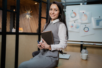 sitting in a modern office, my favorite job is marketing. young confident smart brunette woman with...