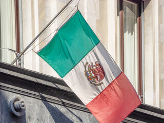 Mexican flag flutters on the facade of a building
