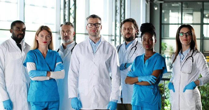 Portrait of multi ethnic women and men, team of doctors colleagues. International medics. Healthcare workers. Mixed-races physicians and nurses looking at camera. Clinic team. Docs at work in hospital