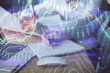 Double exposure of forex chart drawing over people taking notes background. Concept of financial analysis