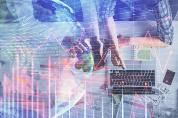 Double exposure of man and woman working together and financial graph hologram drawing. market analysis concept. Computer background. Top View.