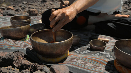 Fototapeta na wymiar Asian guy playing Tibedt singing copper cups on a viewing mountain