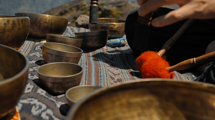 Asian guy playing Tibedt singing copper cups on a viewing mountain