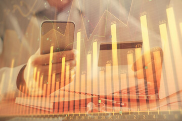 Double exposure of man hands holding a credit card and Forex graph drawing. Stock trading and digital fintech in Internet E-commerce concept.