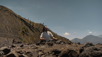 Asian guy playing Tibedt singing copper cups on a viewing mountain