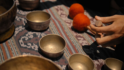 Asian guy playing Tibedt singing copper cups on a viewing mountain