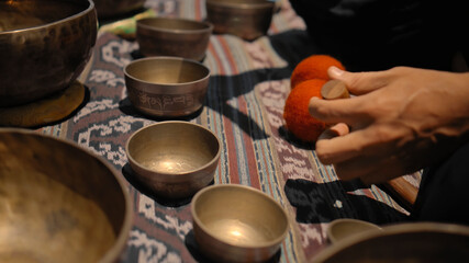 Asian guy playing Tibedt singing copper cups on a viewing mountain