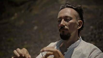 Asian guy playing Tibedt singing copper cups on a viewing mountain