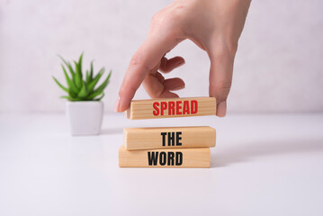 Spread thw word, a word written on a wooden block. Spread the word text on the table, concept