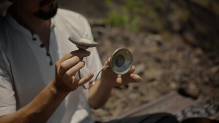 Asian guy playing Tibedt singing copper cups on a viewing mountain