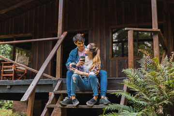 Tourist couple sitting on the stairs drinking coffee. Man and woman drink coffee at stairs.