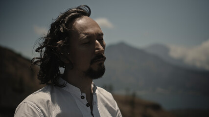 Asian guy playing Tibedt singing copper cups on a viewing mountain
