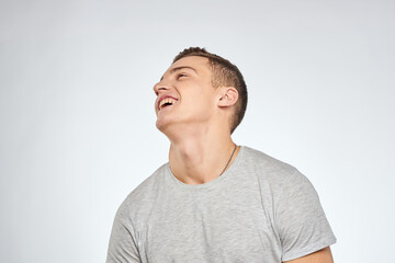 Obraz premium man in gray t-shirt emotions light background cropped view