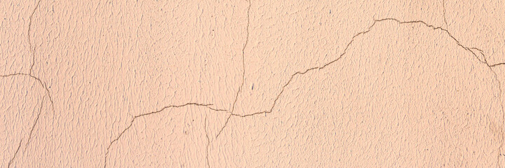 Old wall with cracked plaster. Weathered rough surface. Wide panoramic texture for background and design.