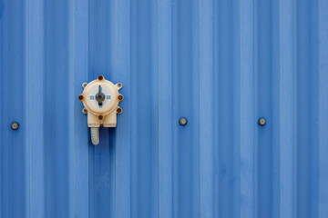industrial power switch on a blue metal fence