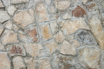 Wall texture of natural chipped stone with cement joints. Decorative stone background.