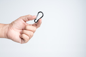 Hand holding small carabiner, mountain climbing hook