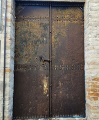 Porta portone in ferro metallico vecchio rovinato arrugginito ruggine muro mattoni antichi chiavistello serratura