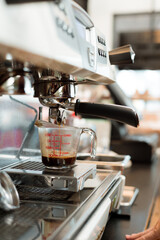 black coffee in measuring cup put on coffee maker