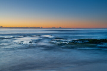 Fototapeta na wymiar Clear skies and soft seas, dawn at the beach