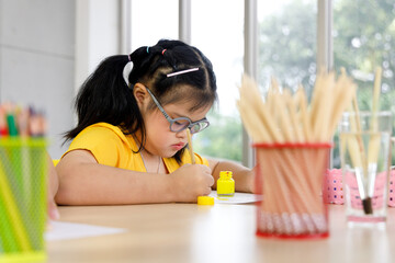 Girl with Down's syndrome painting in art class.