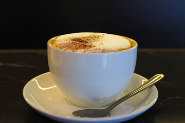 A cup of freshly served Cappuccino coffee. 