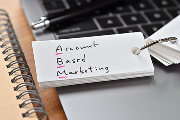 The words "ABM" written in a word book. Close-up. It's an acronym for "Account Based Marketing".