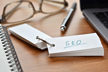 The words "SEO" written in a word book. Close-up. It's an acronym for "Search Engine Optimization".