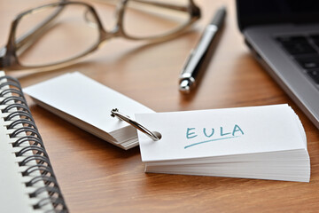The words "EULA" written in a word book. Close-up. It is an acronym for "End User License Agreement".