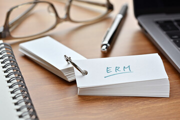 The words "ERM" written in a word book. Close-up. It is an acronym for "Enterprise Risk Management".