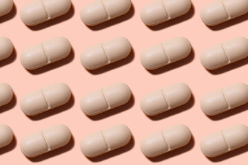 Drug pattern. Repeating beige pills on a beige background. Textured background of beige pills lying in a row. Horizontal, close-up, macro.