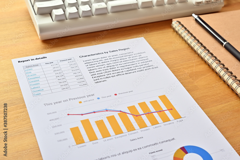 Poster there's a piece of paper with a downward trending line and a bar chart on it, along with a white key