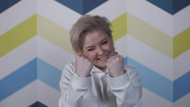 Happy young blonde woman was delighted with this wonderful news. Motivated business woman, Good work result. Emotions of an attractive girl from business success.
