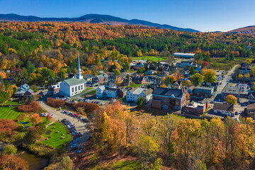 Aerial view of charming small town Stowe in Vermont. Mountains with fall multicolor trees - 387509486