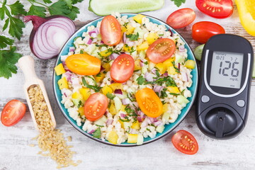 Glucose meter with sugar level, salad with vegetables and bulgur groats, tape measure. Diabetes and healthy meal containing natural vitamins