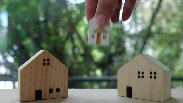 Hand change of small home to big home. Concept of Home sales and real estate investors