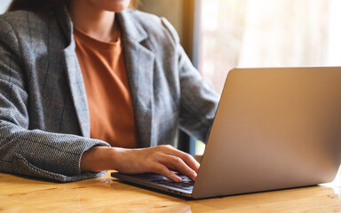 Closeup image of a businesswoman working and typing on laptop computer keyboard on the table