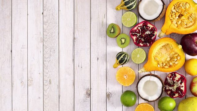 Fresh sliced fruits appear on right side of light wooden theme. Stop motion 
