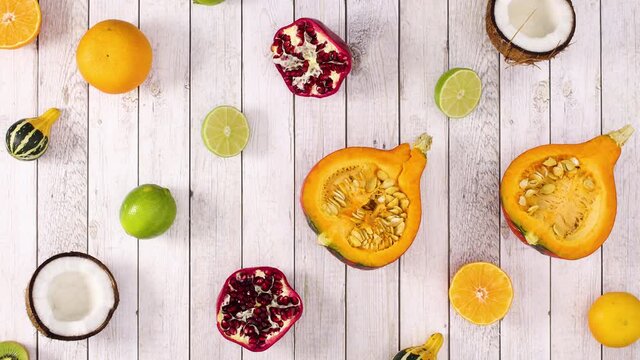 Sliced tropic and citrus fruits moving in a rows up and down on wooden theme. Stop motion 