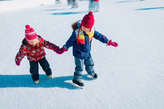 little girls skating together in winter nature