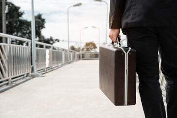 Asian business man walk and carry a bag to apply for a job. Failure and layoff concept to the disease Covid-19 and unemployed.