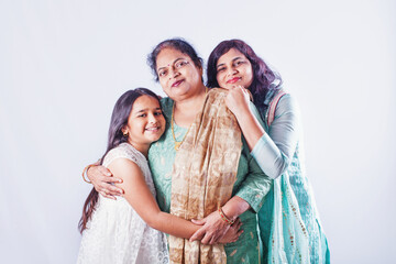 Female generations: Indian grandmother, mother and daughter posing together over studio white background