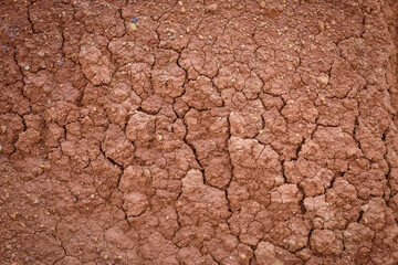 Top view cracked red soil. Picture of natural disaster. Drought land, global warming and deforestation. Image of brown soil texture, close up. Desert realistic background.