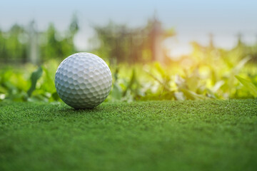 Golf ball on the green with warm tone and sunset. Golf ball on Green field golf course in morning time with soft sunlight