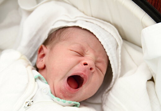 little baby wrapped in blanket sleeping in bed at home stock photo