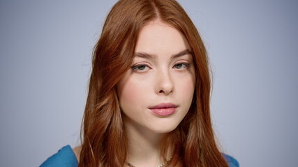 Naklejka premium Sensual girl posing in studio. Sexy woman raising eyes at lens on gray