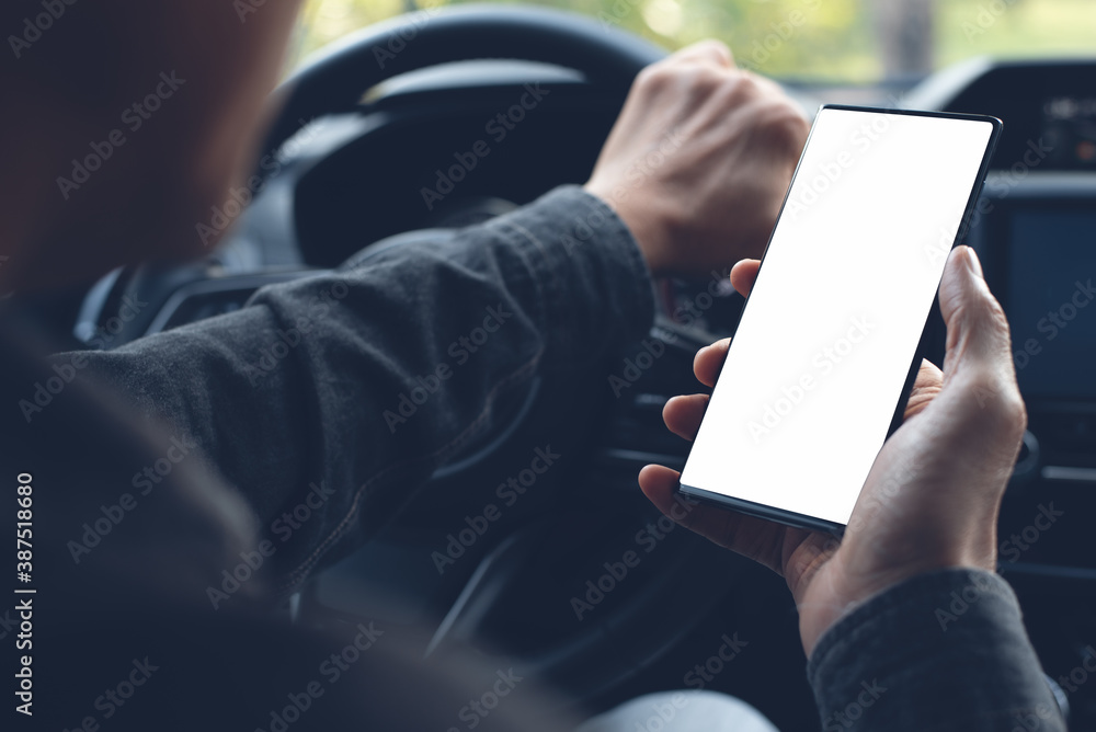 Poster mockup of man hand holding blank screen mobile phone inside a car using navigator app searching loca