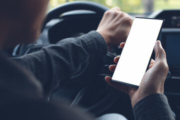 Mockup of man hand holding blank screen mobile phone inside a car using navigator app searching location 